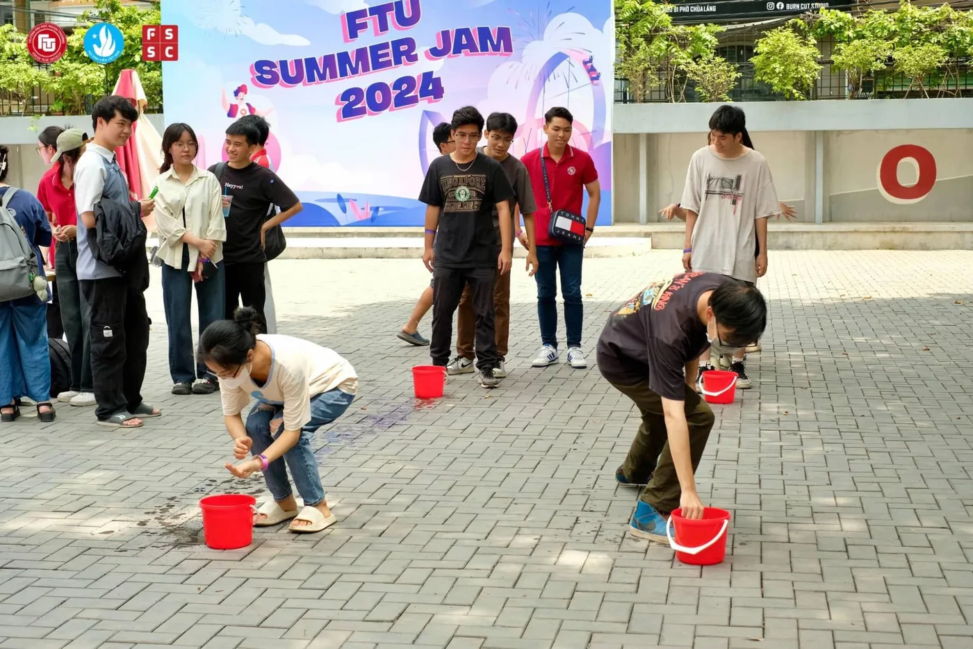 A water-bucket game running in front of the Summer Jam backdrop