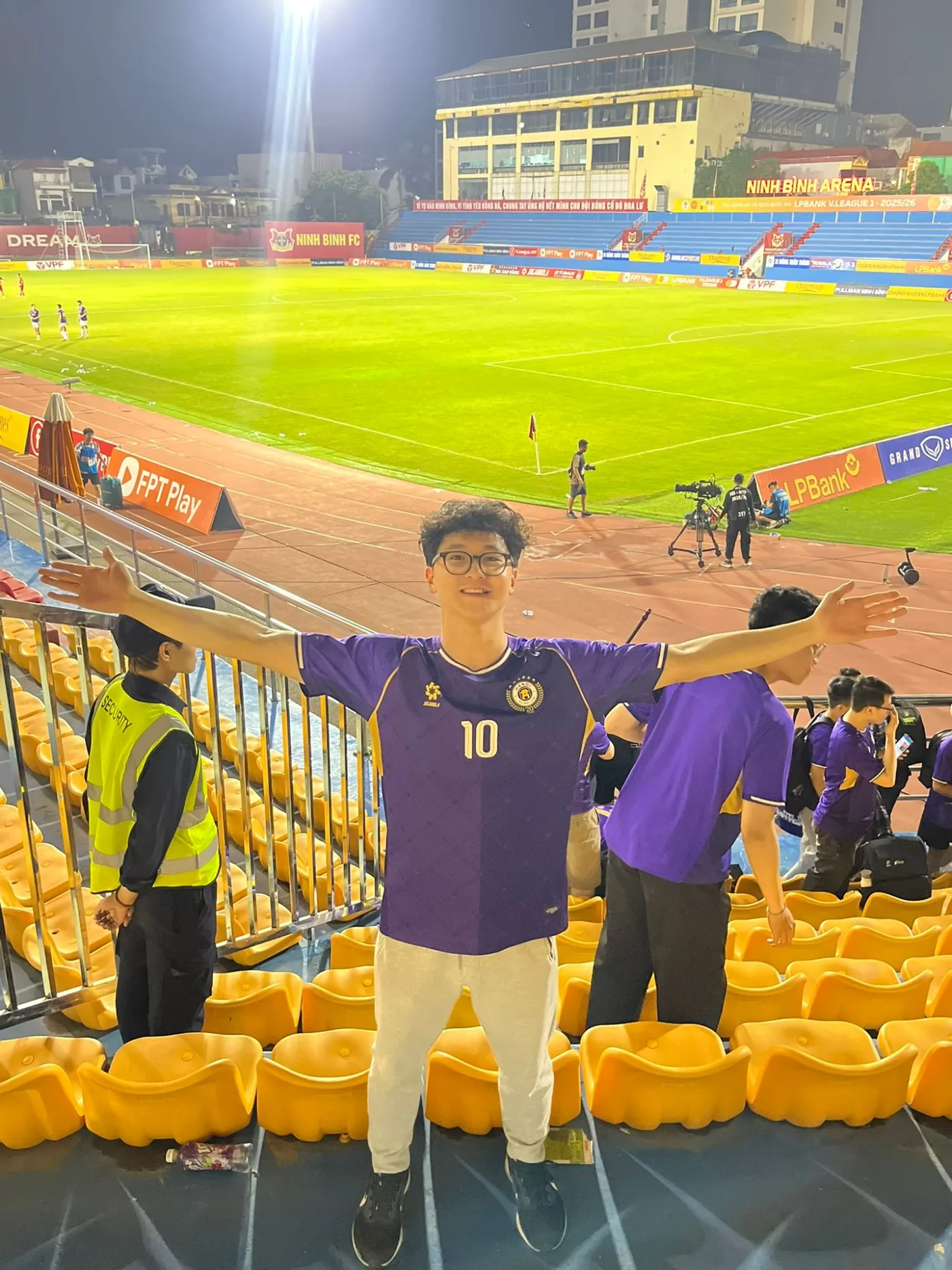 In a Hà Nội FC shirt in the stands at Ninh Bình Arena